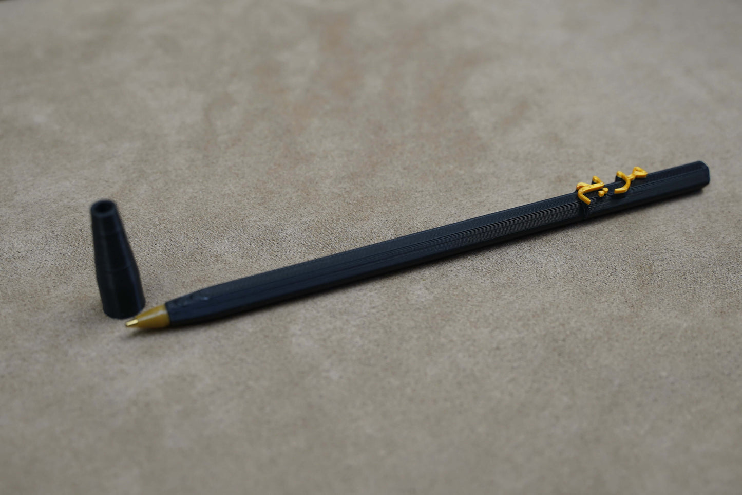 Personalised pen on a beige surface, featuring a unique design and a removable cap for a customized writing experience.