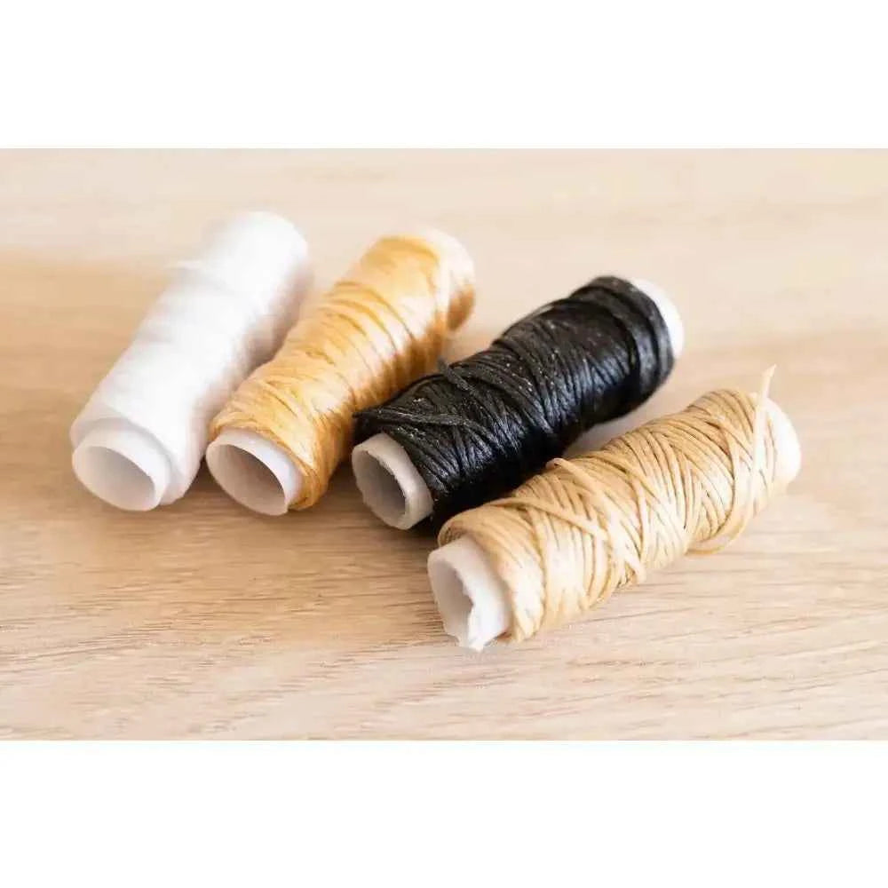 Book binding sewing set featuring spools of thread in white, gold, black, and beige colors for crafting projects