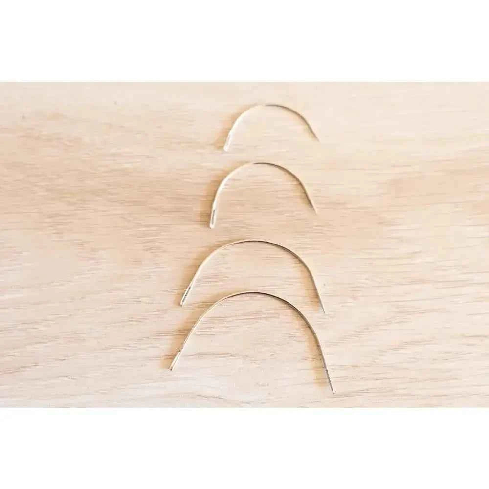 Set of curved needles for book binding sewing set by The Create Studio on a wooden surface