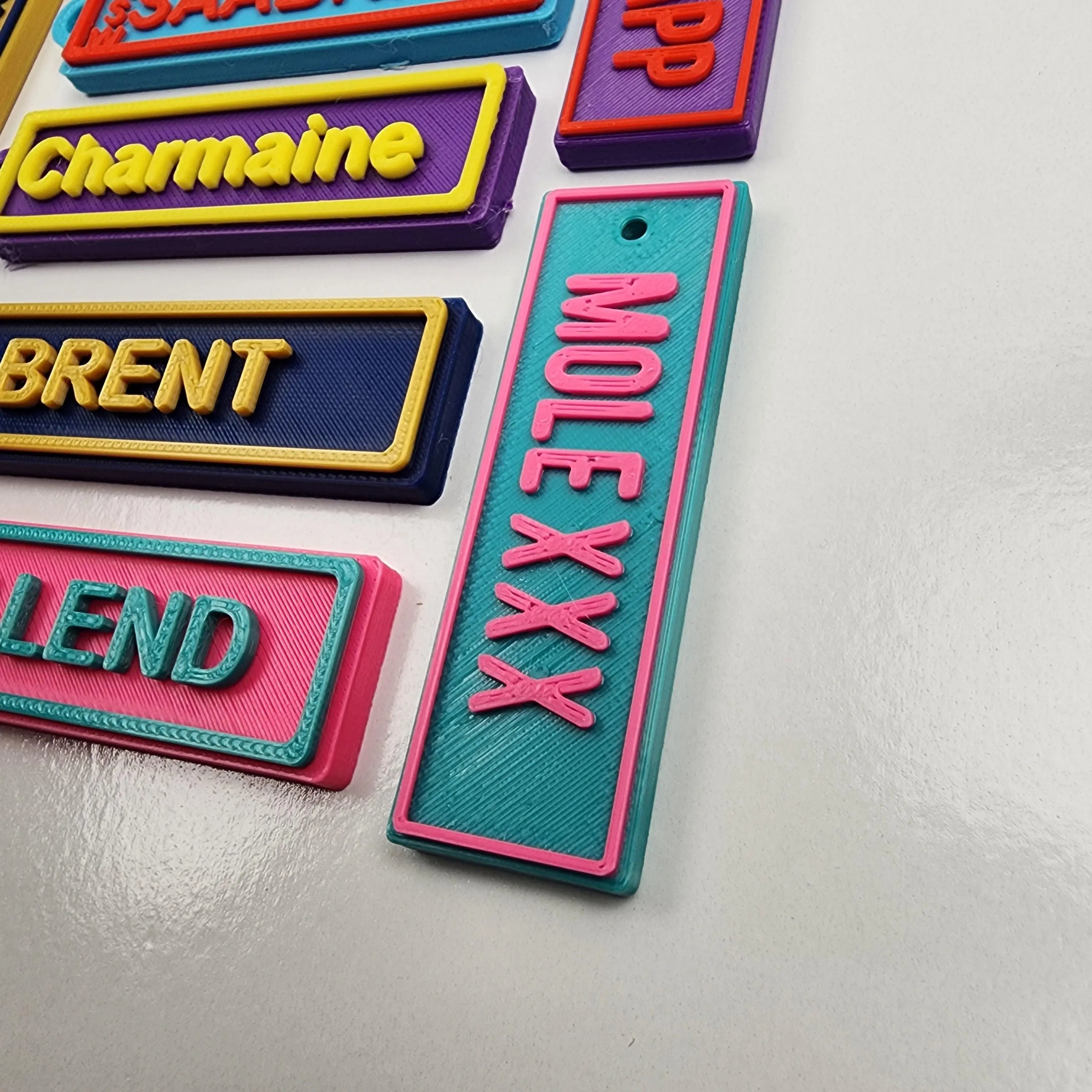 Colourful Car Rego Keychains displayed in various names and designs from The Create Studio