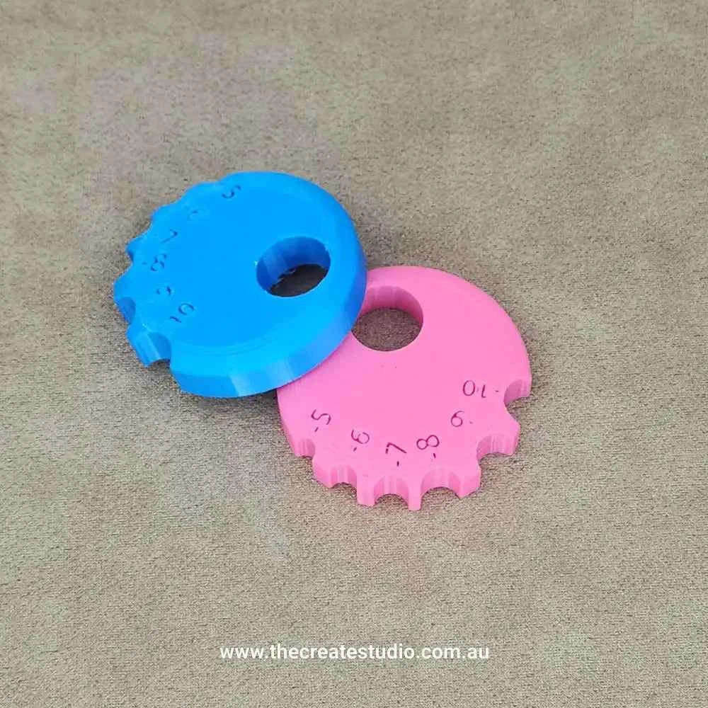 Two colorful round rib tools for ceramics, one blue and one pink, designed for shaping and smoothing clay.