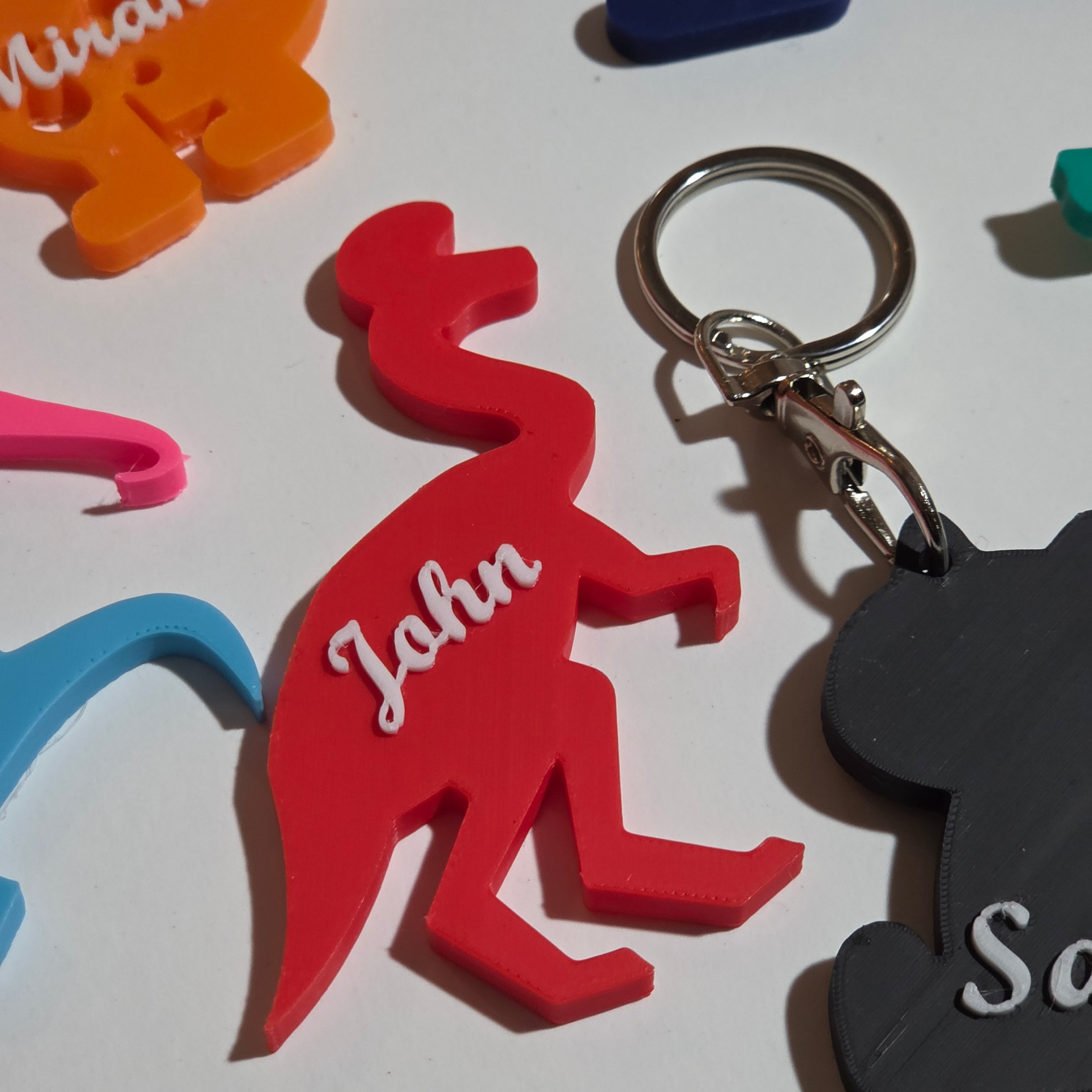 Custom name dino keychain featuring the name John in bright red design