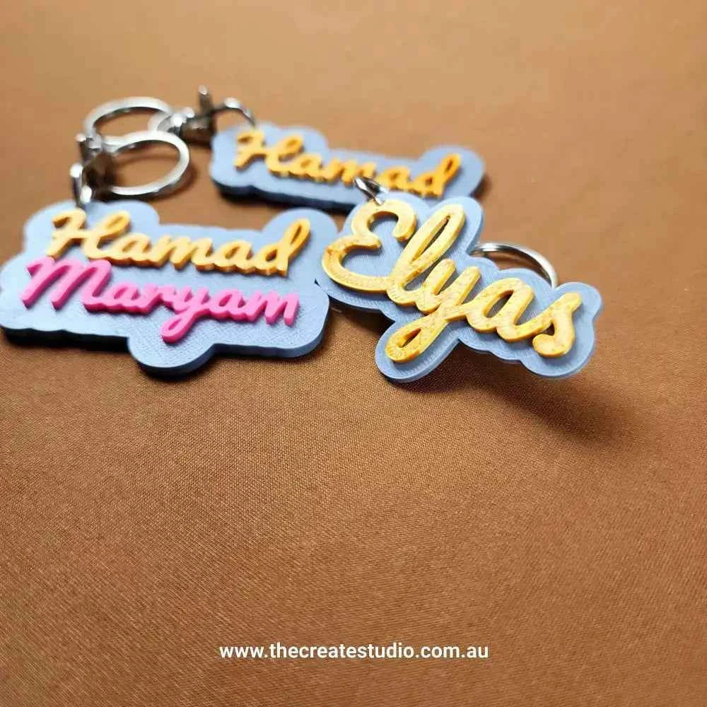 Custom name keychain featuring vibrant designs with names Hamad, Maryam, and Elyas