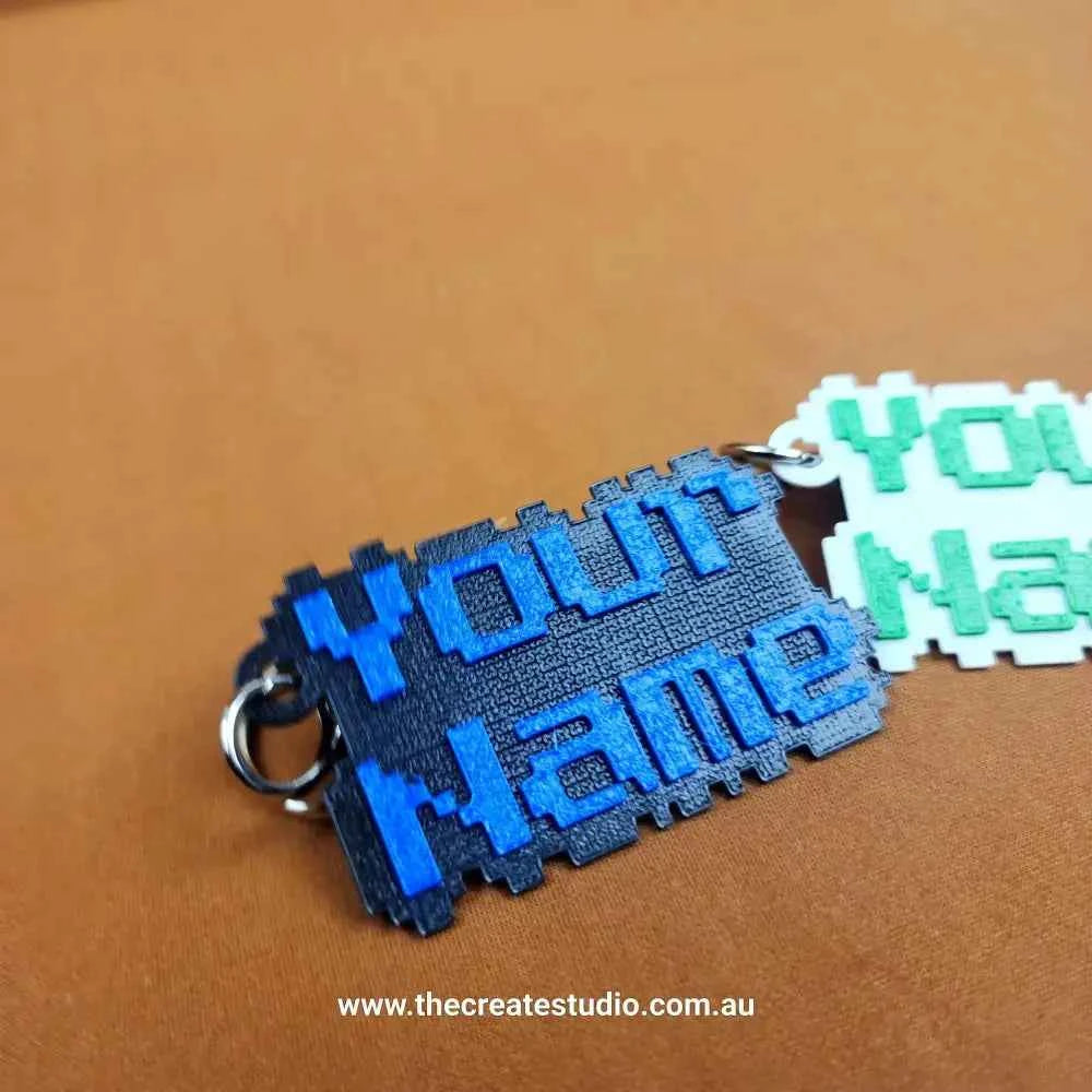 Custom pixelated name keychain featuring vibrant blue and green letters as a personalised accessory
