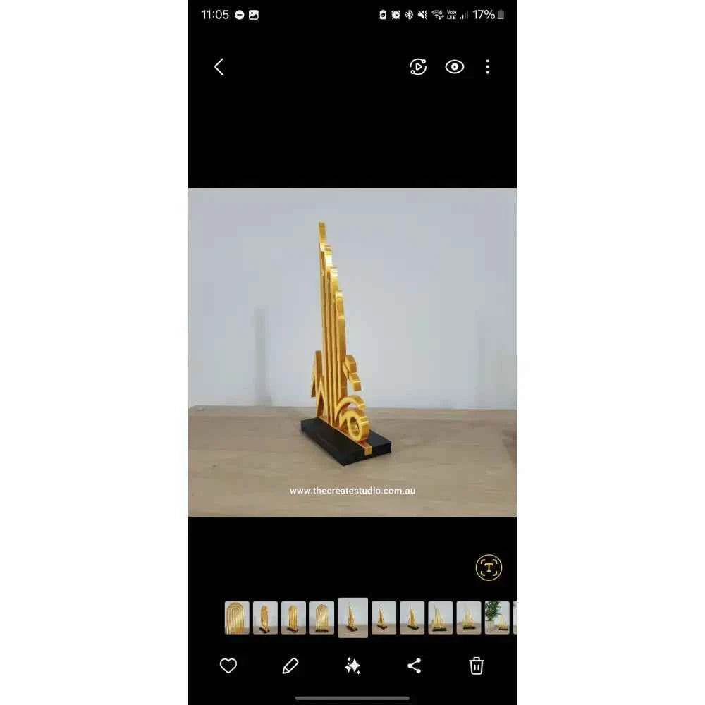 Intricate Islamic calligraphy tabletop art in gold, showcasing elegant designs on a sleek black base