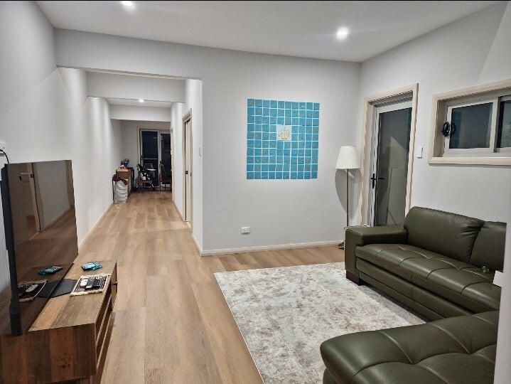 Modern living room featuring 99 Names of Allah wall art in blue with white calligraphy above sofa