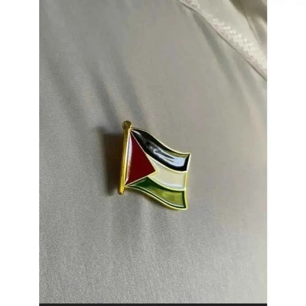 Palestine flag lapel pin with vibrant colors displayed on a fabric background