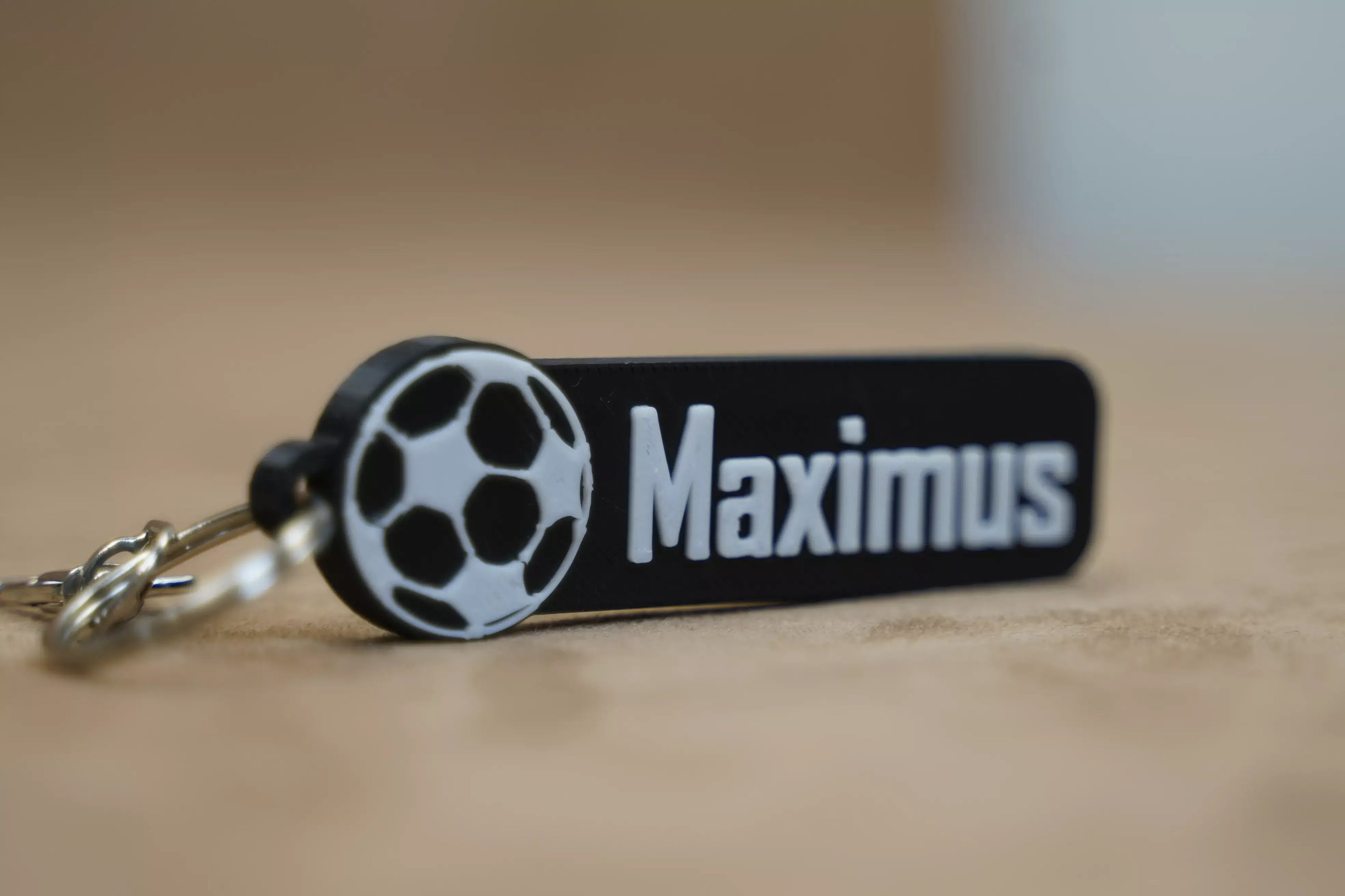 Personalised football keychain with the name Maximus and a football design