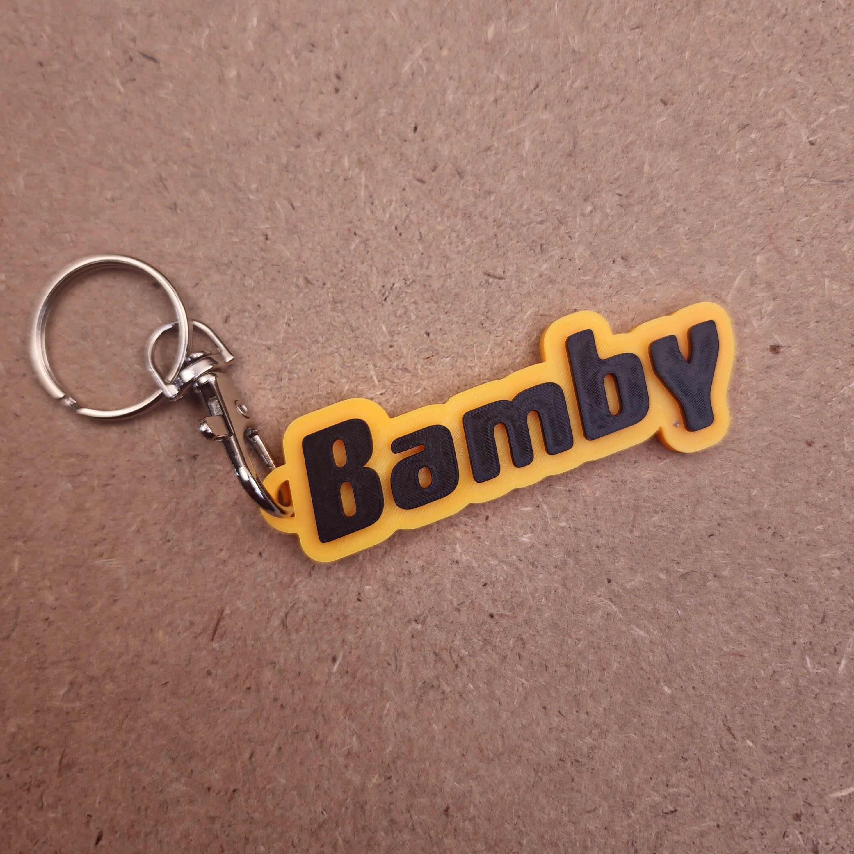 Personalised keychains with modern fonts featuring a yellow and black design with the name Bamby