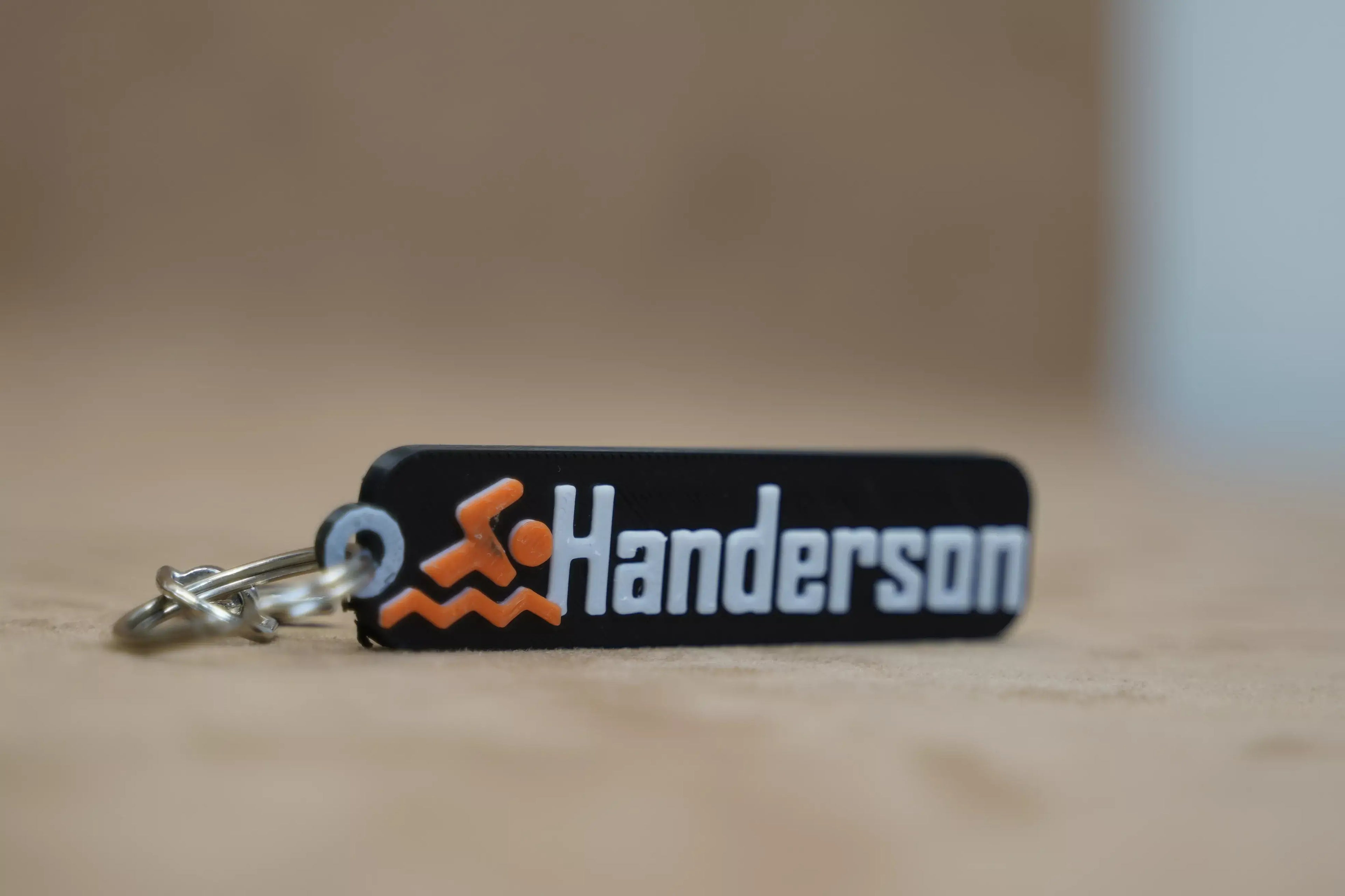 Personalised swimmer keychain featuring the name Henderson with a swimming icon