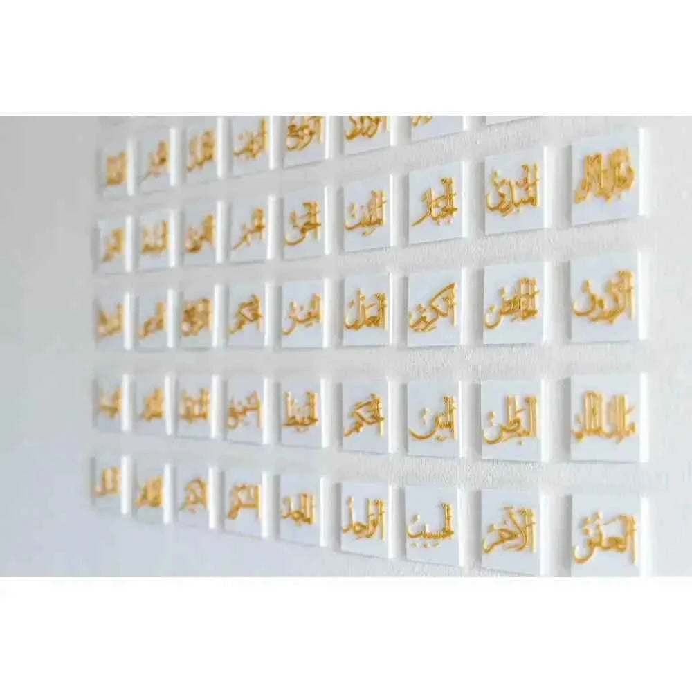 99 Names of Allah wall art with gold Arabic calligraphy on white tiles by The Create Studio