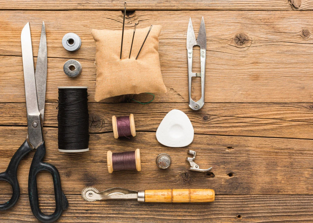 Personalized book binding tools including scissors, thread, needles, and a bone folder for creative projects