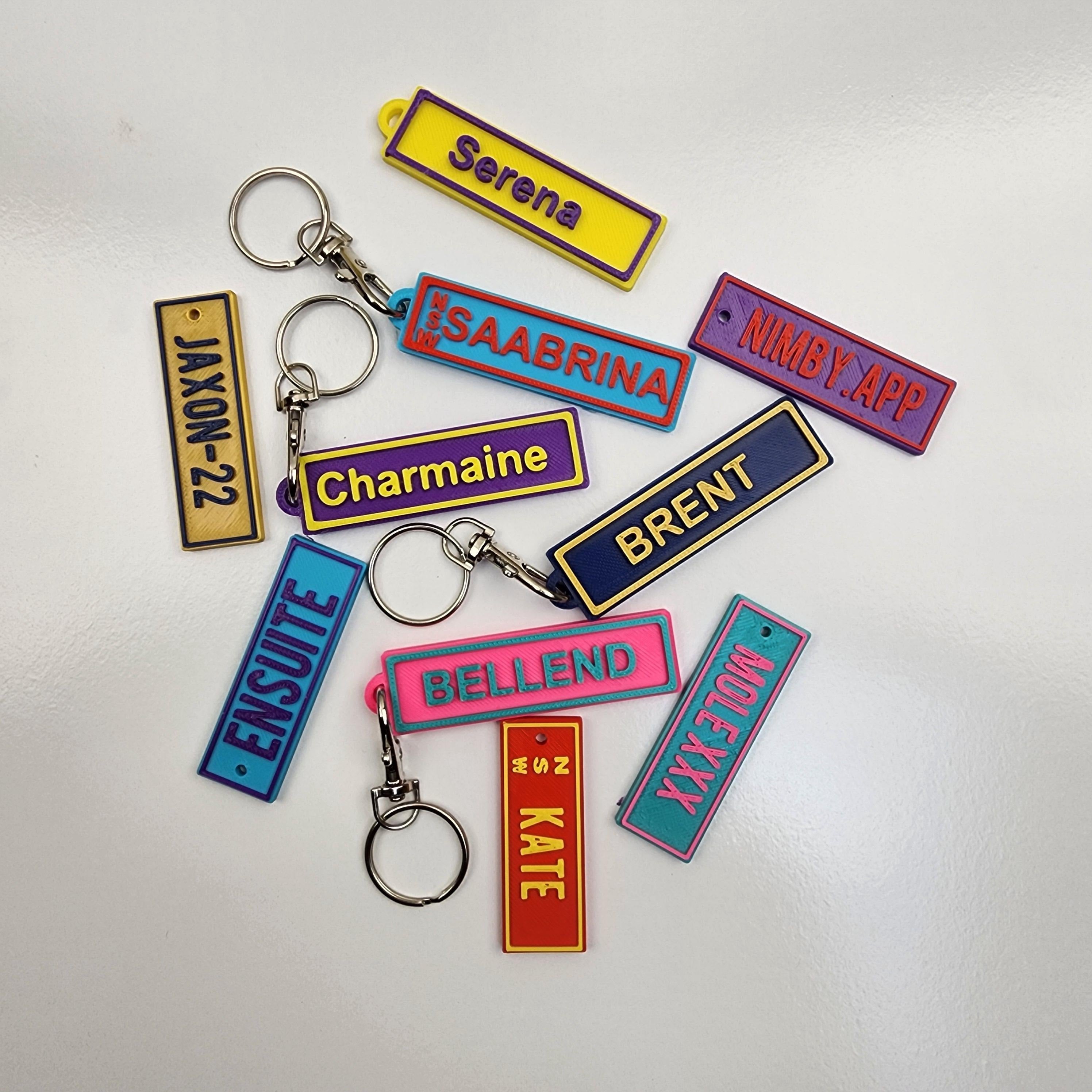 Custom name keychains arranged in a variety of vibrant colours and bold designs showcasing unique names