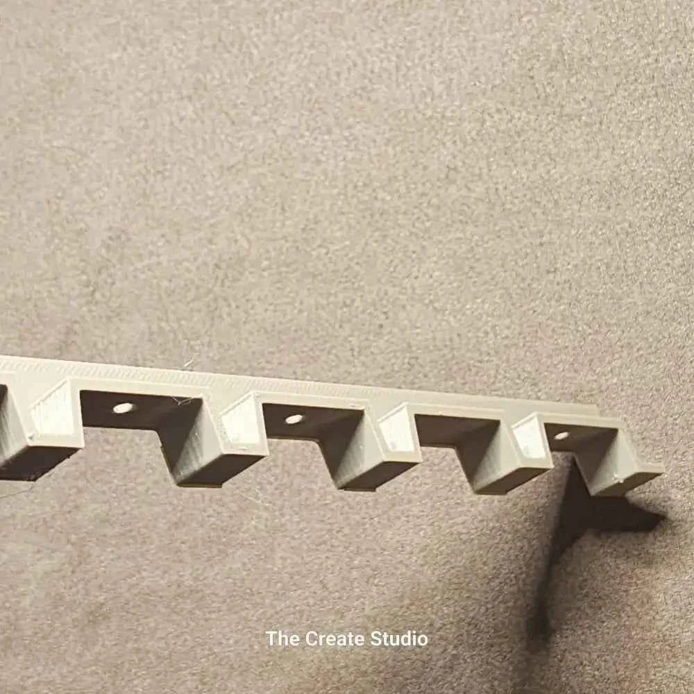 White plastic bee hive frame spacer with angled notches and fixing holes mounted on neutral background by The Create Studio