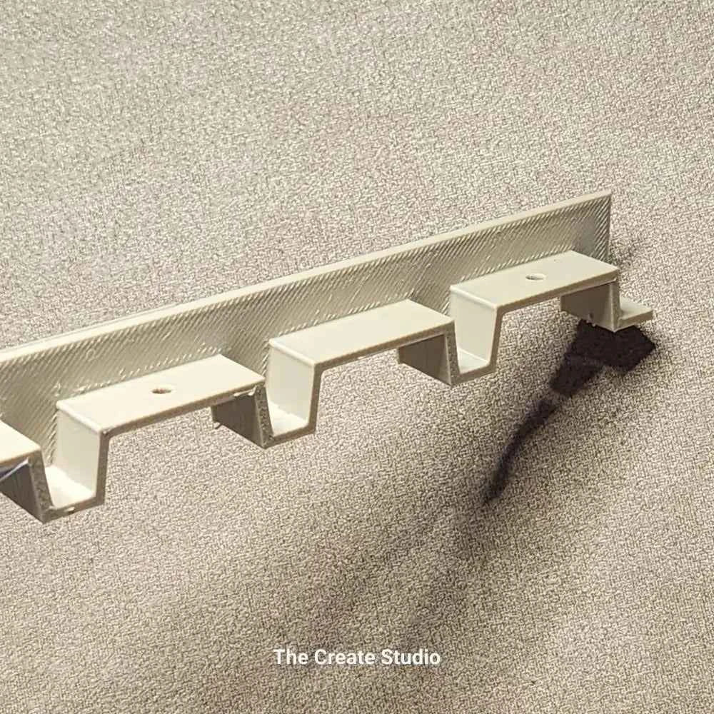 White plastic bee hive frame spacer wall mount rack by The Create Studio for holding multiple frames