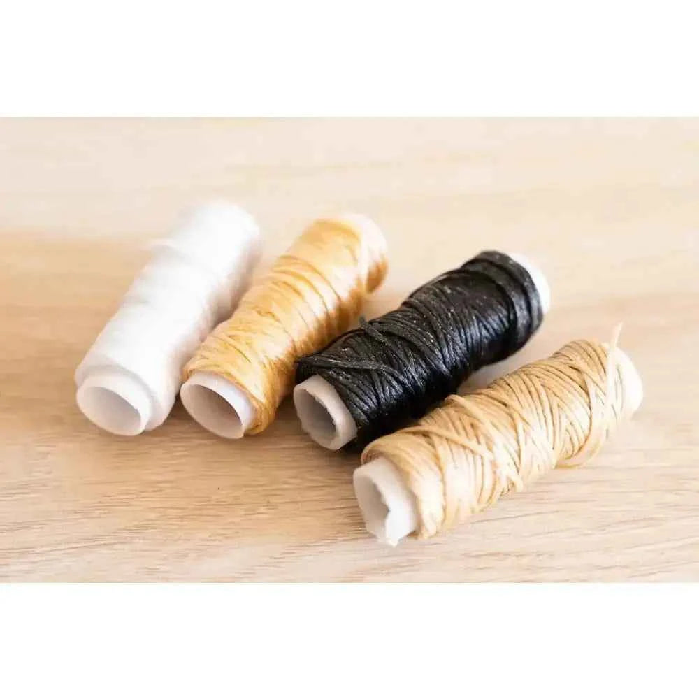 Book binding sewing set with four spools of thread in white, yellow, black, and natural colors