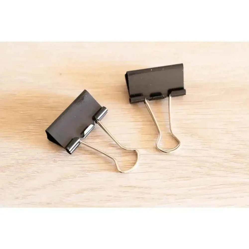 Two black binder clips for organizing papers, ideal for a book binding sewing set