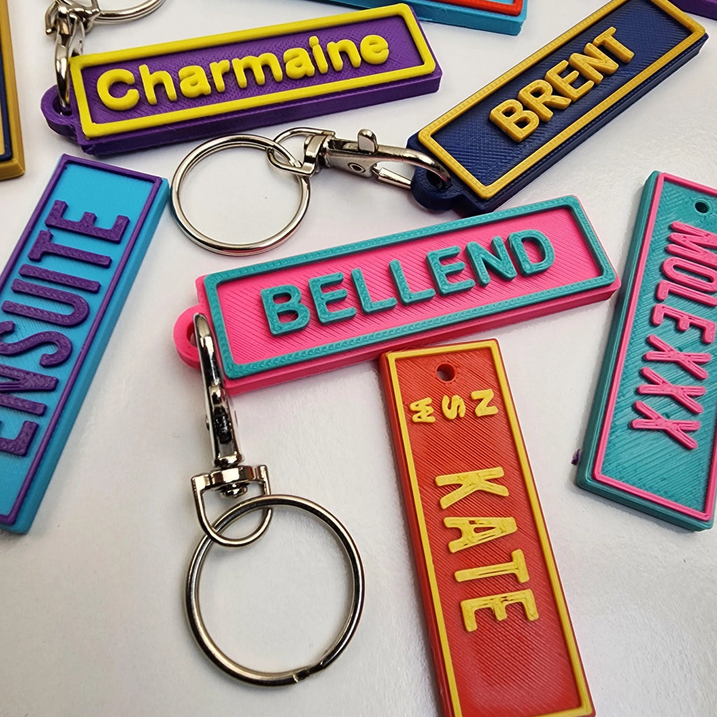 Colourful Car Rego Keychains featuring personalised names and a sturdy metal ring