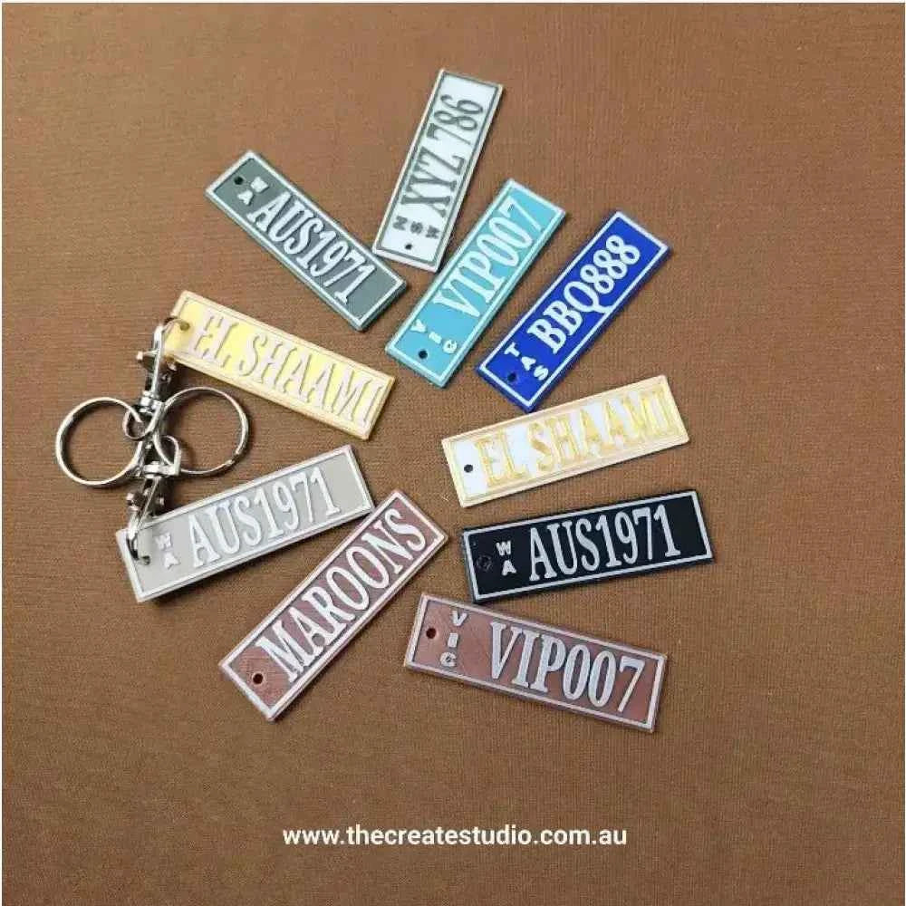 A variety of Car Rego Keychains in different colors and designs on a brown background