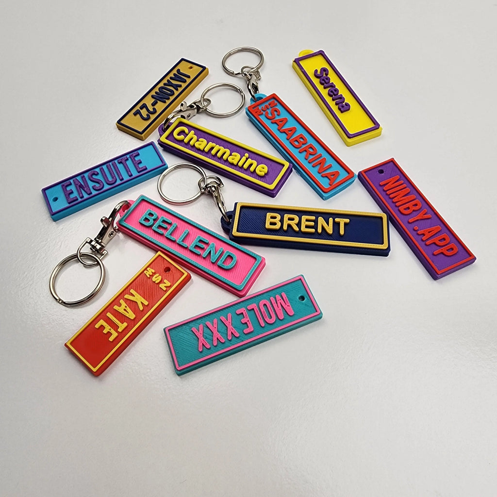 Colourful Car Rego Keychains featuring various names and designs for personalised accessorising