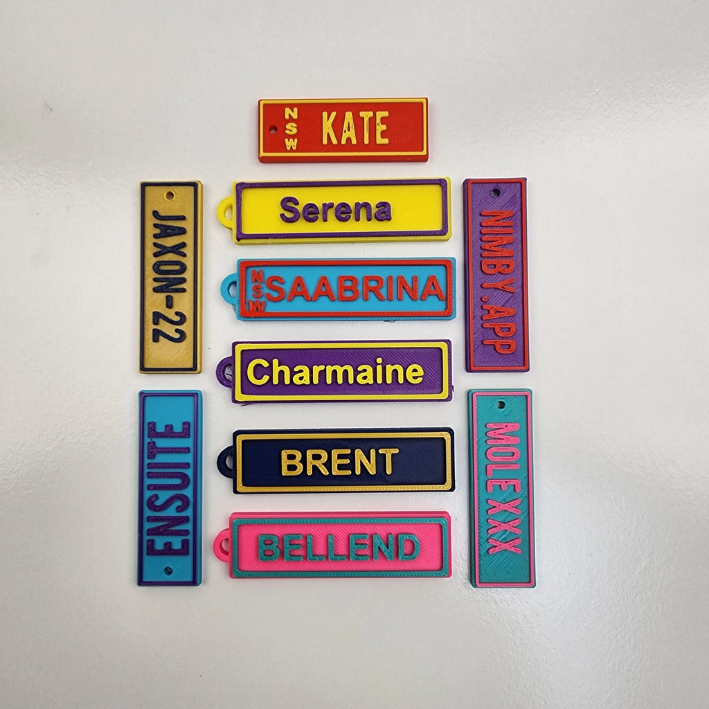 Colourful Car Rego Keychains featuring personalised names and vibrant designs from The Create Studio