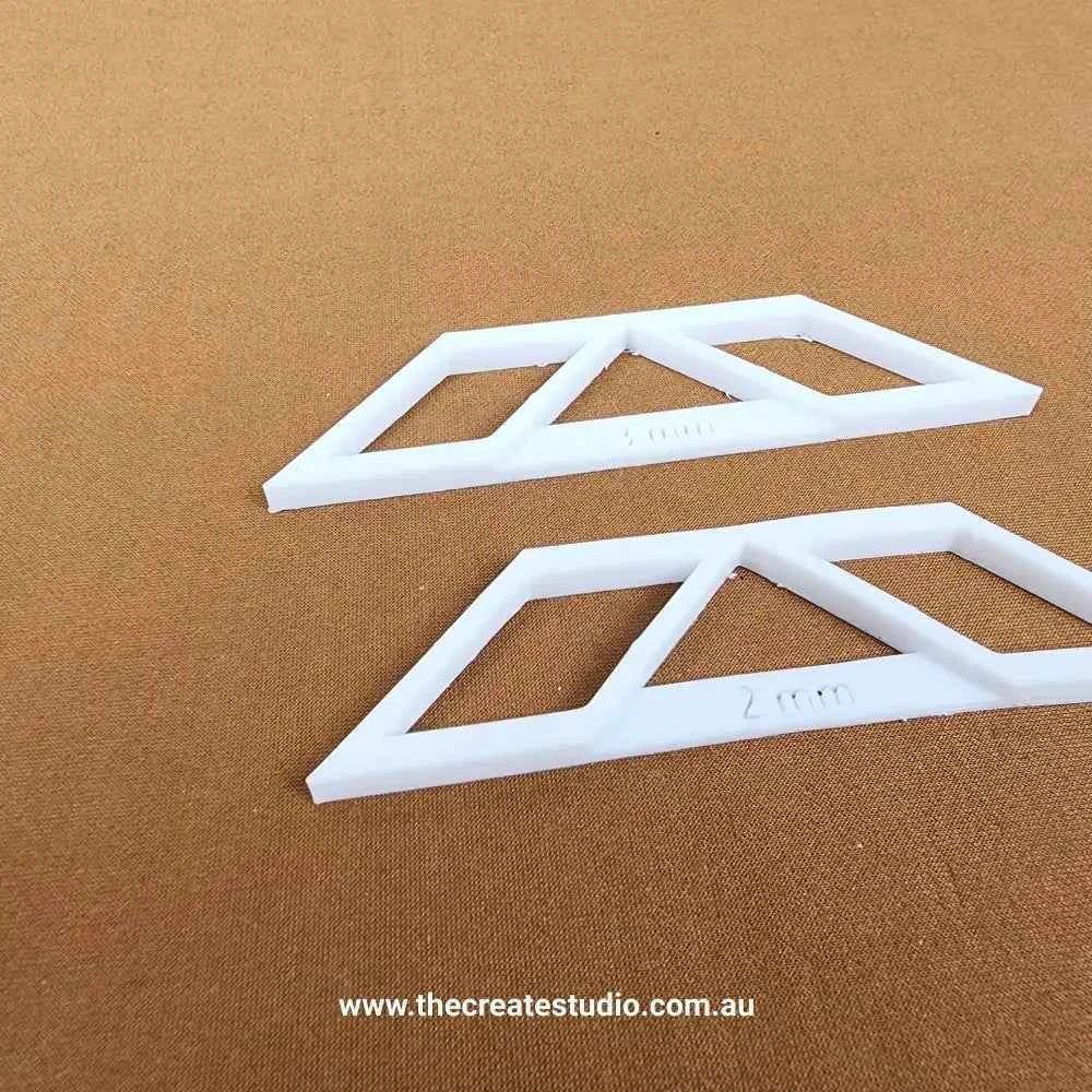 Two white book binding corner tools designed for precise edge trimming and crafting projects