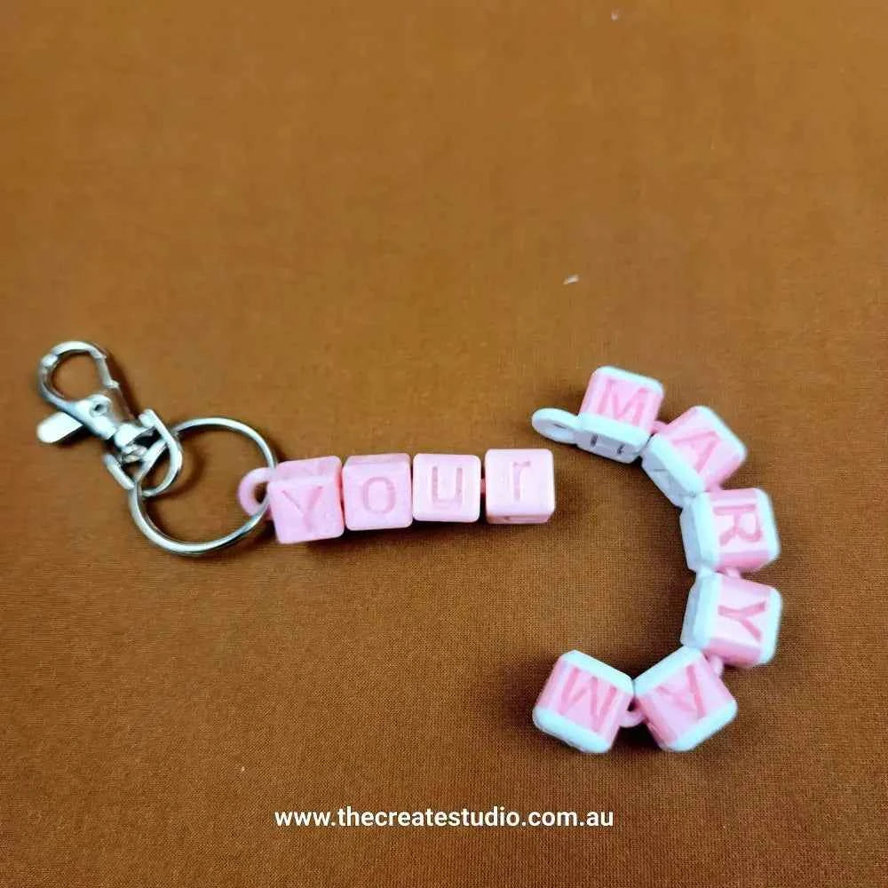 Personalised name keychain in pink and white featuring custom letters for unique style