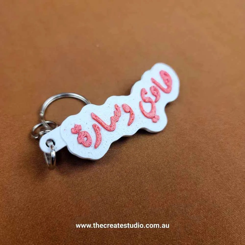 Custom Arabic name keychain in pink and white design, ideal for personalized gifts