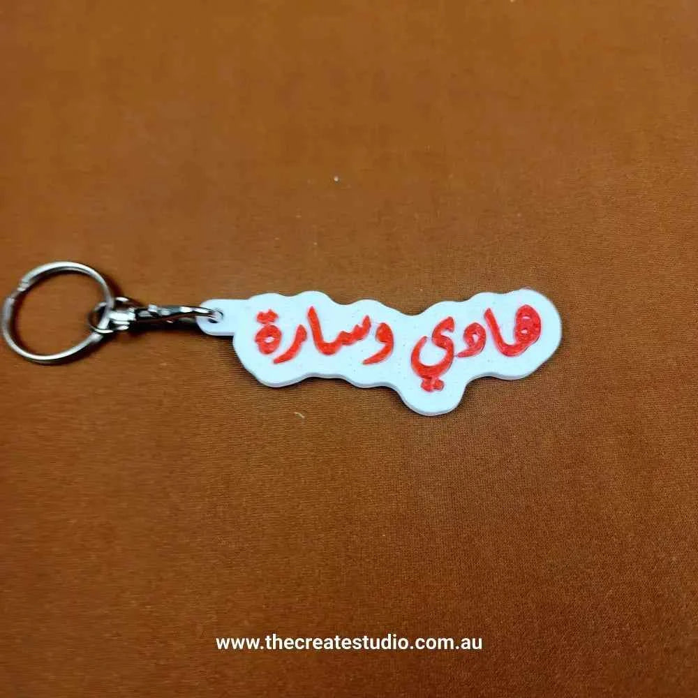 Custom Arabic name keychain featuring vibrant red lettering on a white background
