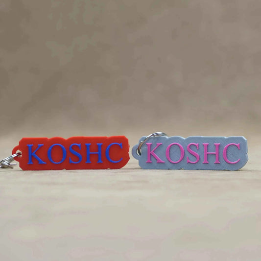 Custom font keychains in red and gray featuring 'KOSHC' in bold letters for personalized style