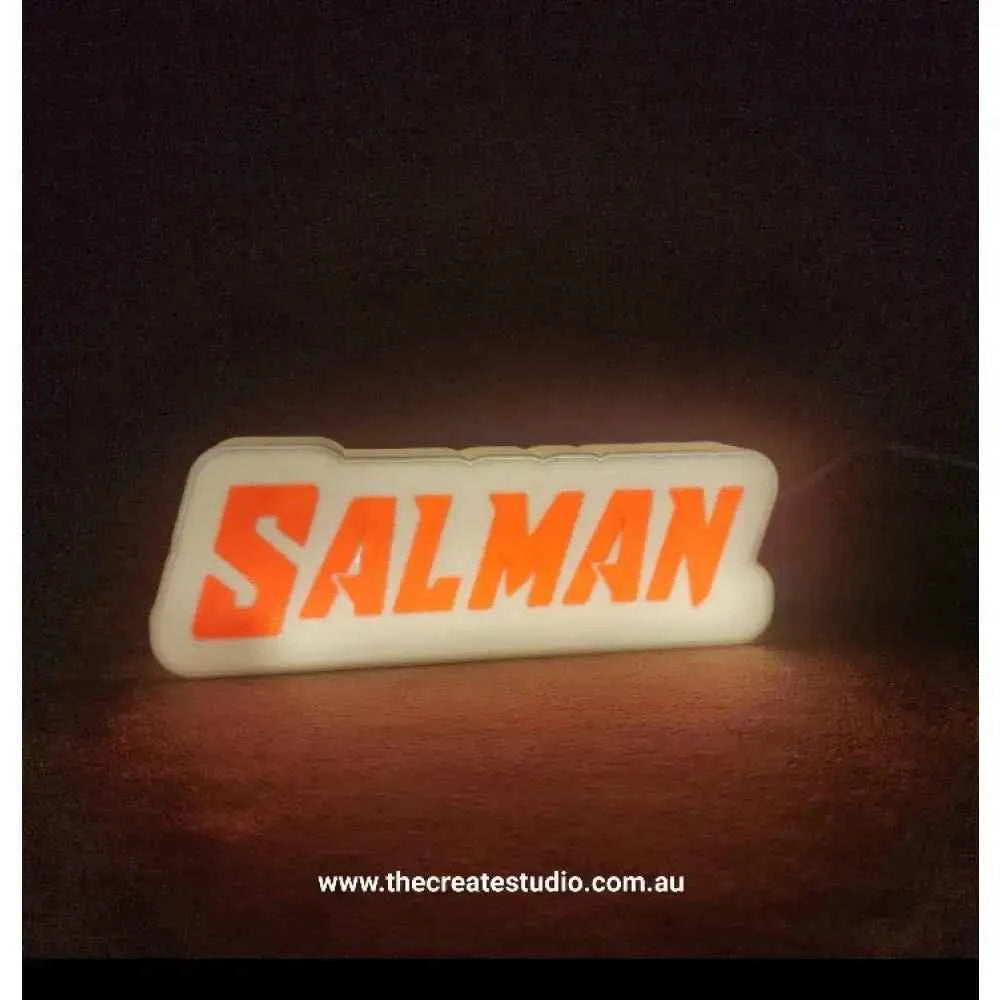 Custom gift light box featuring bright orange text that spells SALMAN, ideal for personalized decor