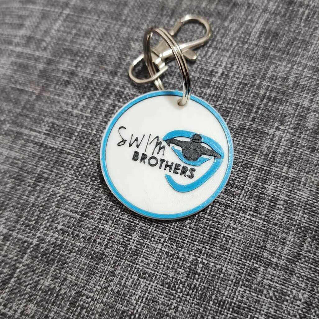 Custom keychain for companies featuring a blue and white design with swim logo and text