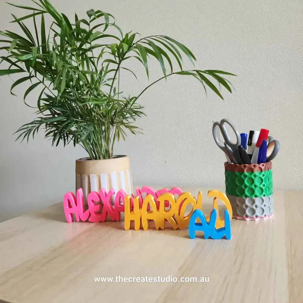 Colorful custom name decor gift featuring personalized names on a wooden table with plants