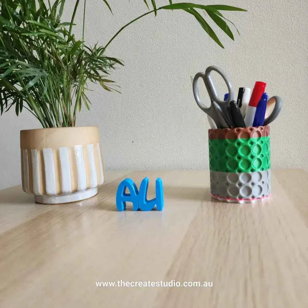 Colorful custom name decor gift displayed with stationery and plants on a desk