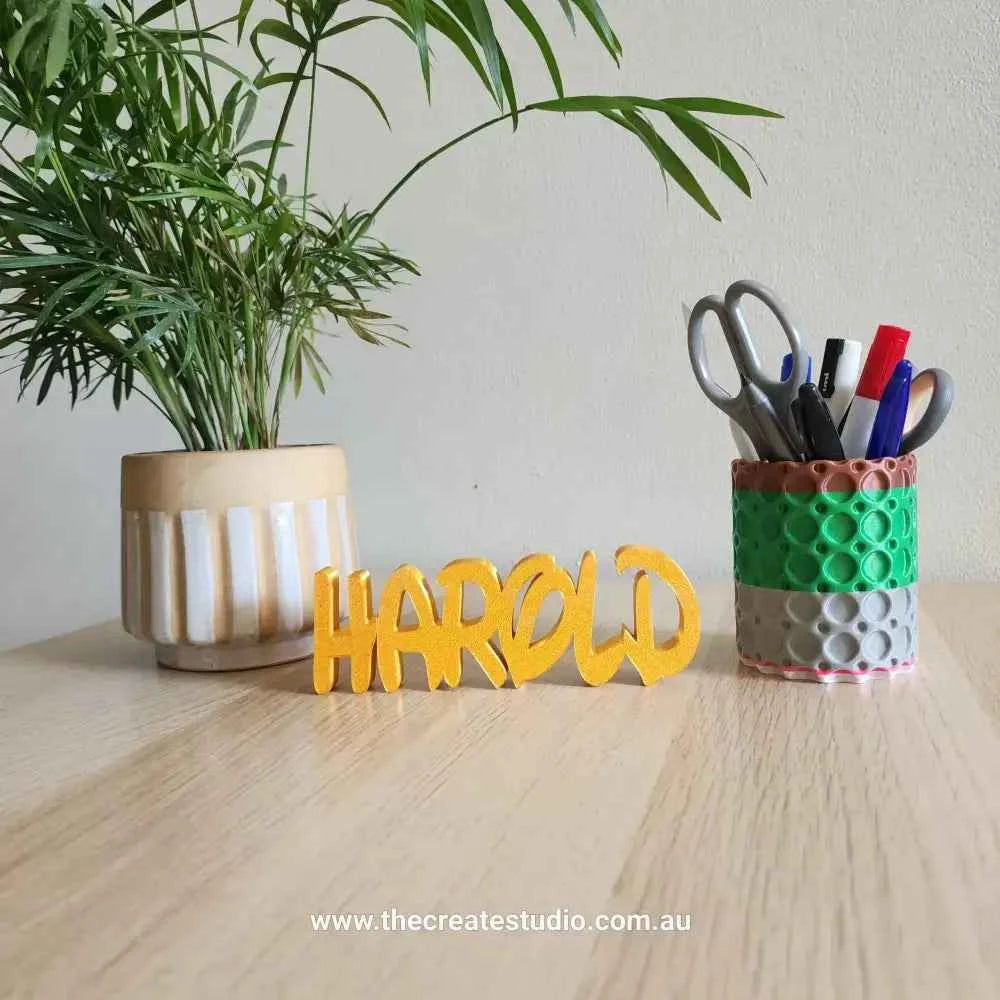 Custom name decor gift featuring the name HAROLD in yellow, displayed on a wooden table with a plant