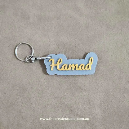 Custom name keychain in grey and gold featuring the name Hamad for personalized style
