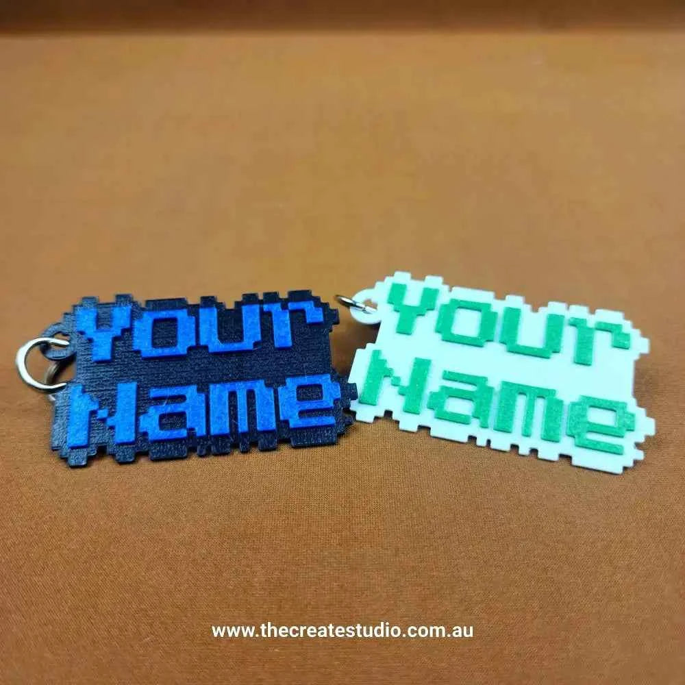 Custom pixelated name keychain in blue and green with personalised text for an original accessory