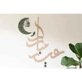 Elegant Eid celebration decor featuring artistic calligraphy and moon lantern designs for festive ambiance