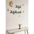 Eid Mubarak home decoration with crescent moon and lanterns on a wall for festive celebrations
