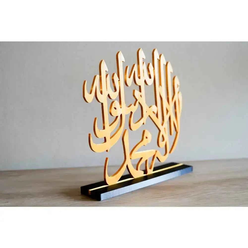 Elegant Islamic calligraphy table decor in gold, beautifully displayed on a black base
