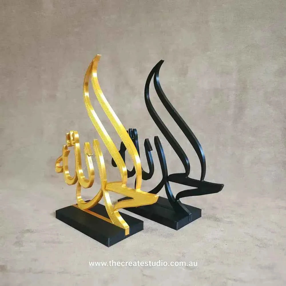Elegant Islamic table decor featuring gold and black calligraphy sculptures on a base