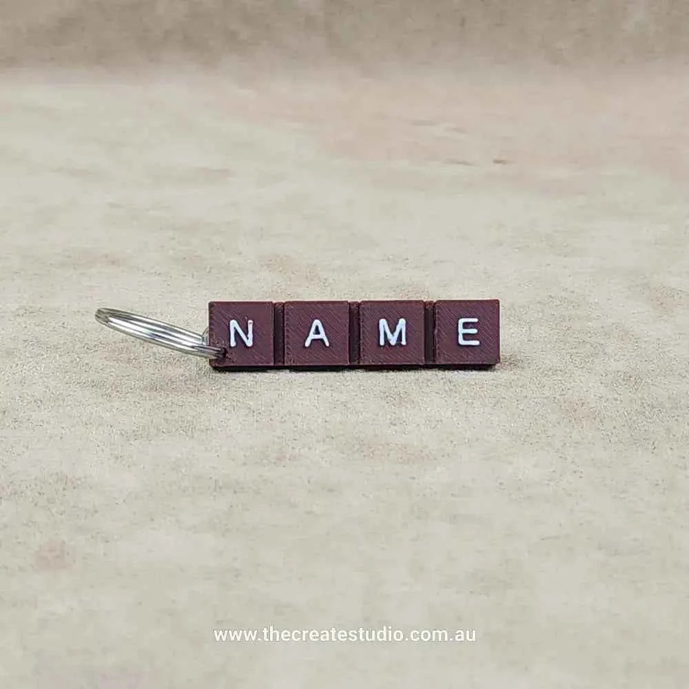 Personalised chocolate bar keychain with custom name letters on a brown background