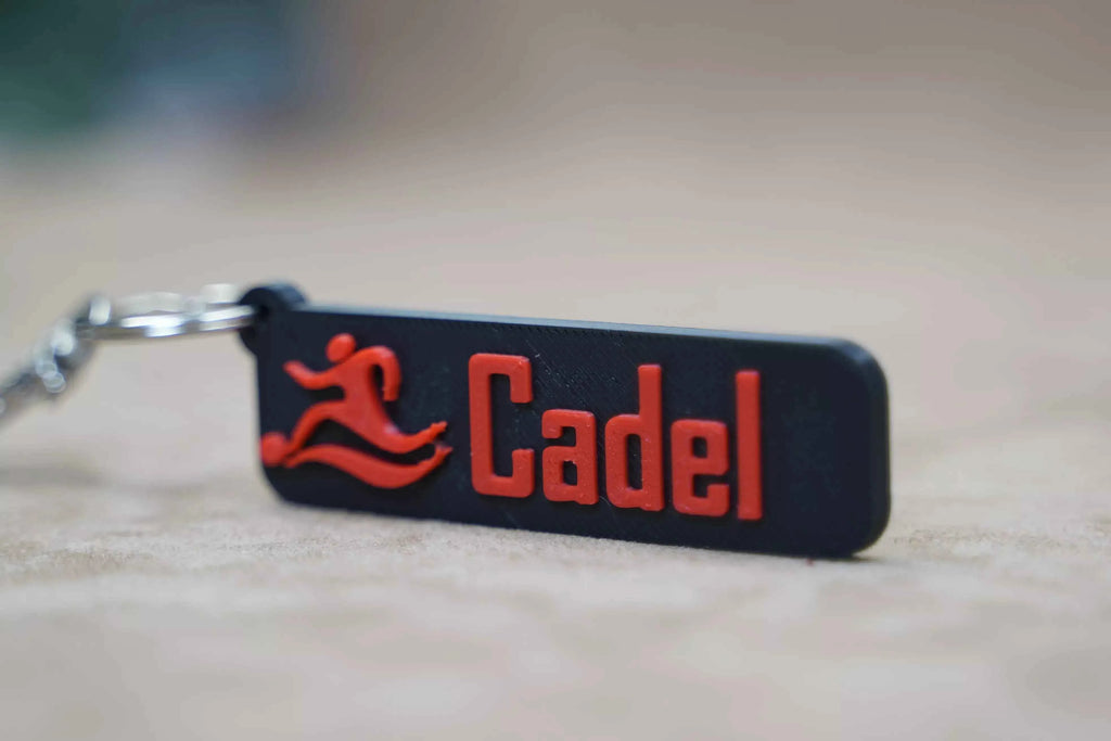 Personalised football keychain featuring the name Cadel in vibrant red and black colours