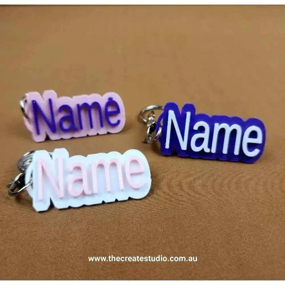 Three personalised name keychains in pink, white, and purple from The Create Studio