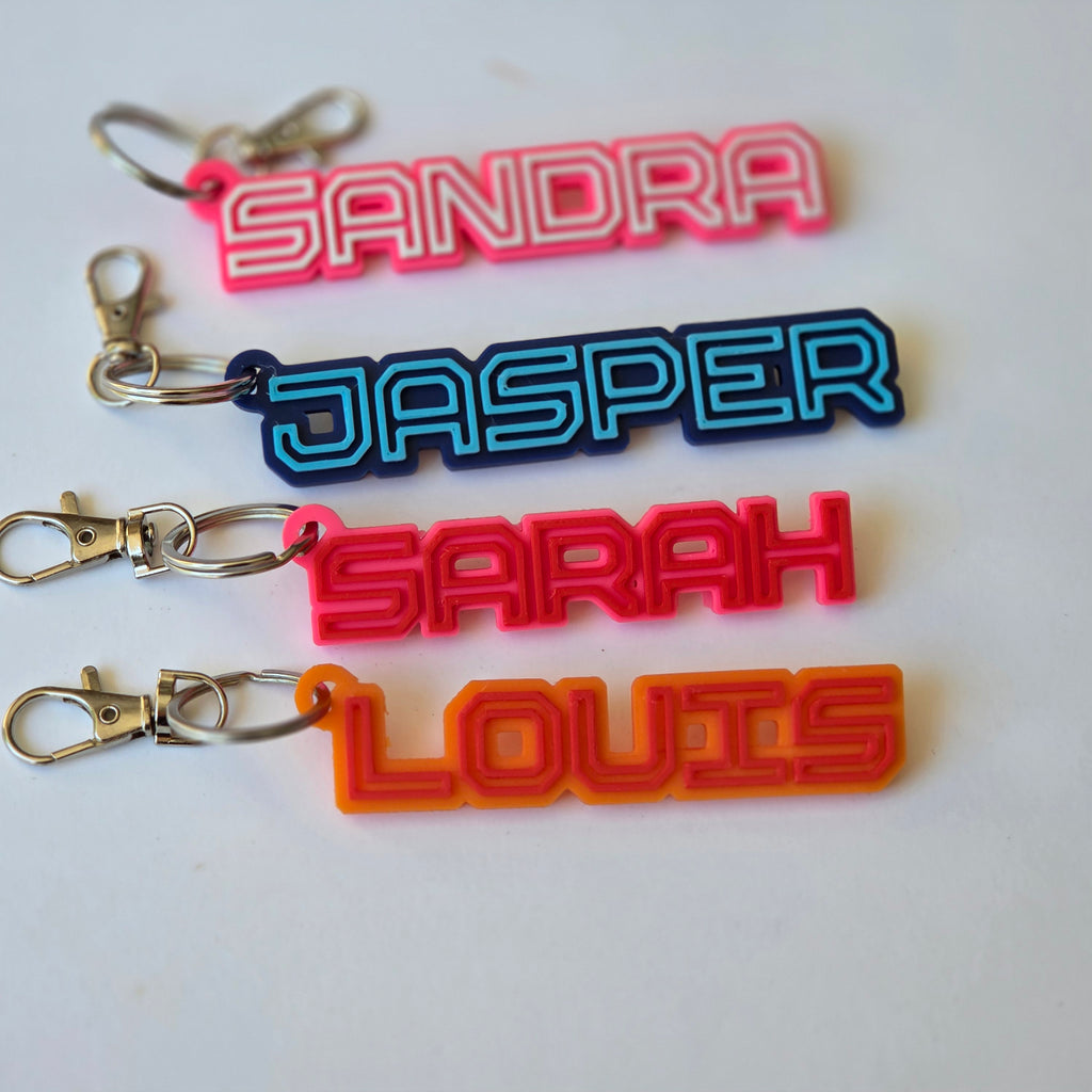 Colourful personalised name keyring set featuring names: Sandra, Jasper, Sarah, and Louis