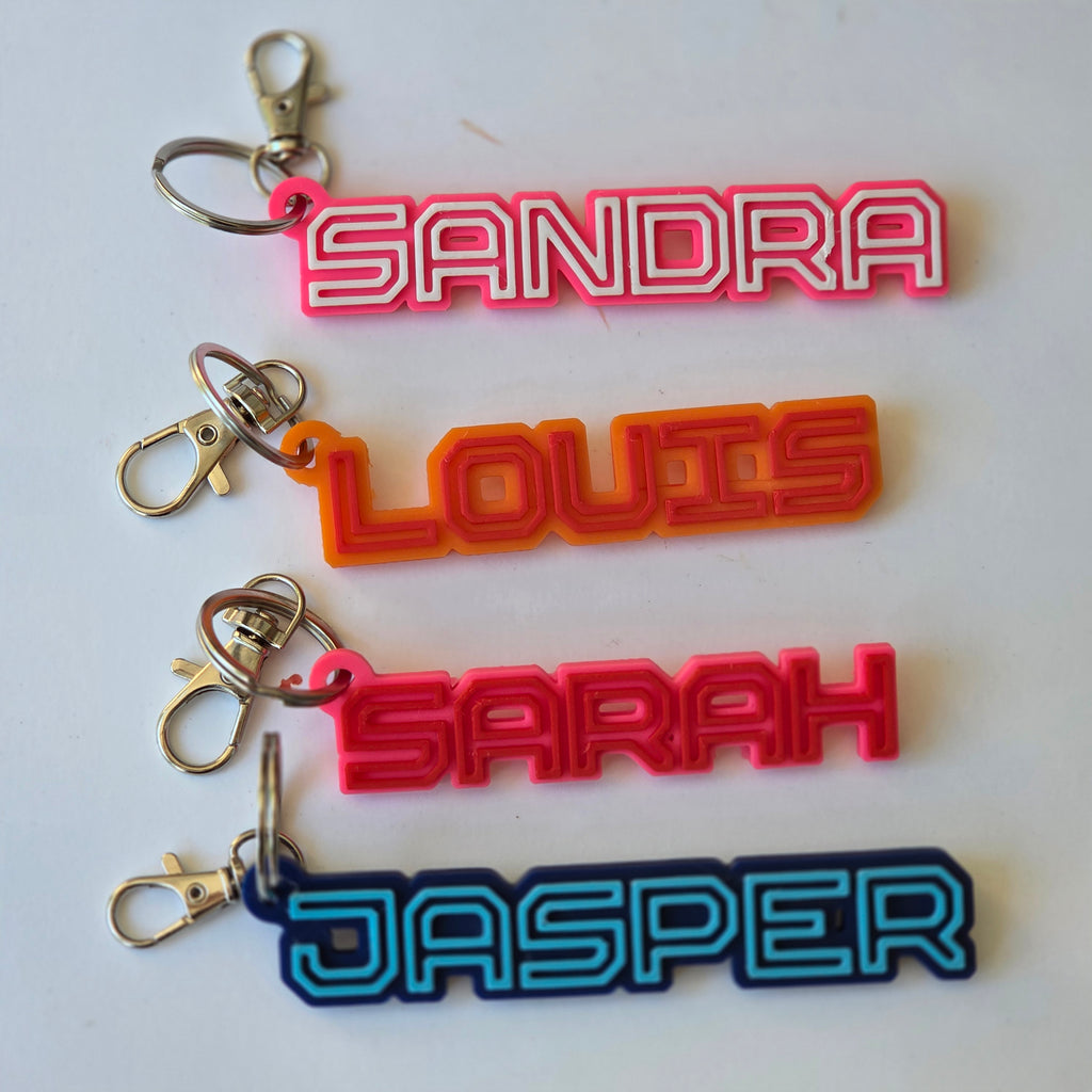 Colourful personalised name keyring collection with names Sandra, Louis, Sarah, and Jasper