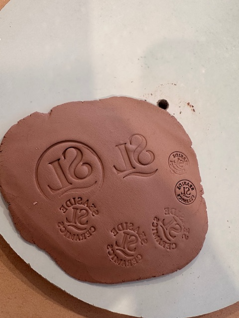 Personalised pottery stamp impressions on clay showing unique designs for custom pottery projects