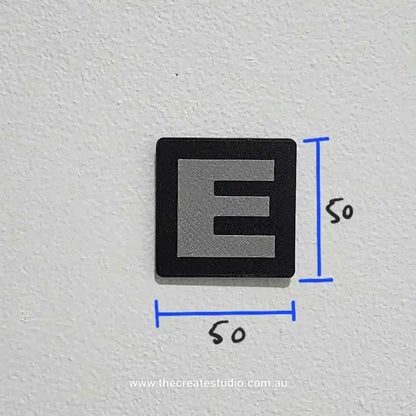 Personalised family tree gift featuring a sleek black square with a stylized letter E in gray